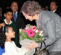 Doña Sofía recibe de manos de una niña un ramo de flores a su llegada a Guatemala